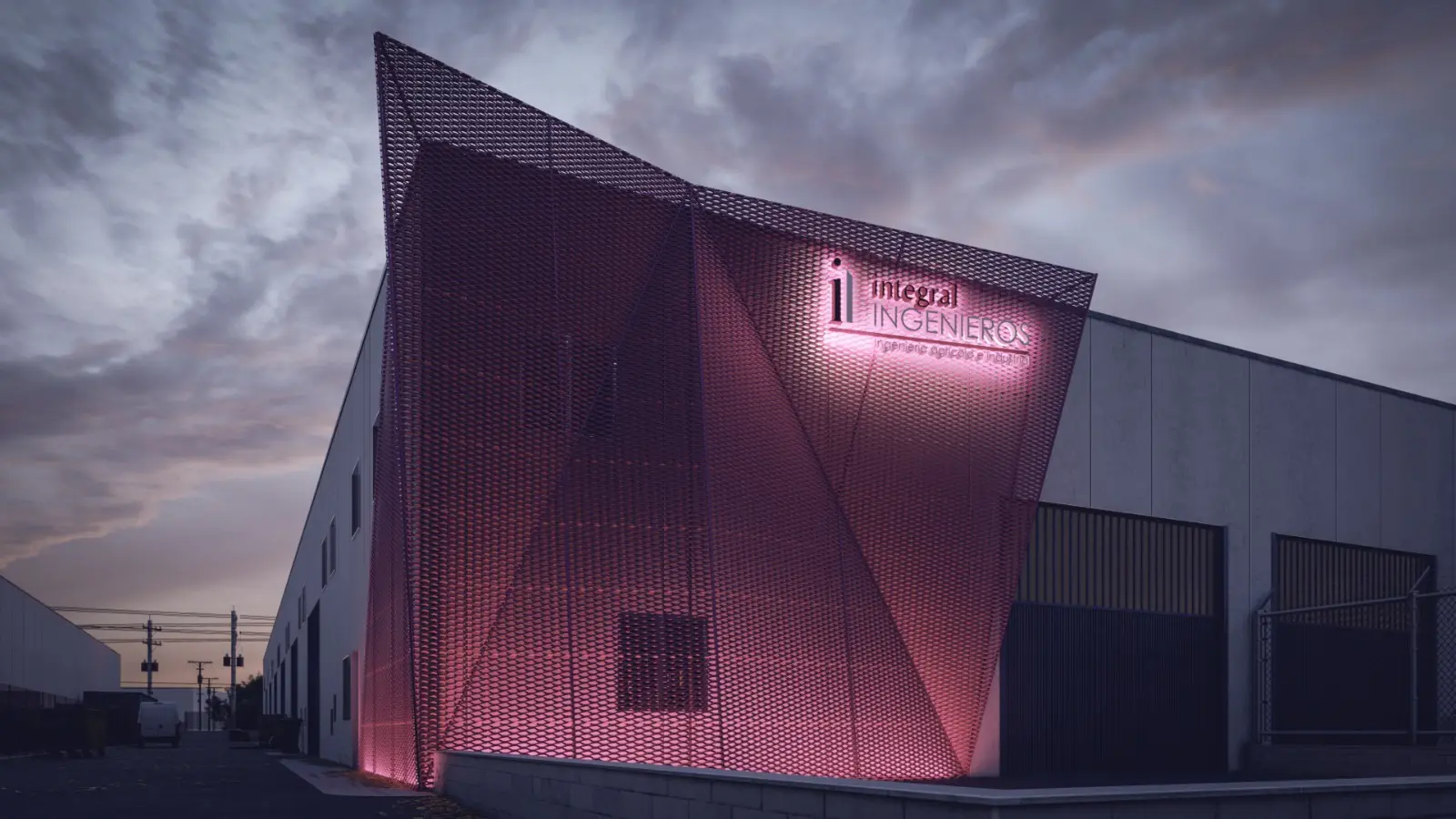 Nave de Integral Ingenieros con la fachada de malla magenta iluminada al anochecer